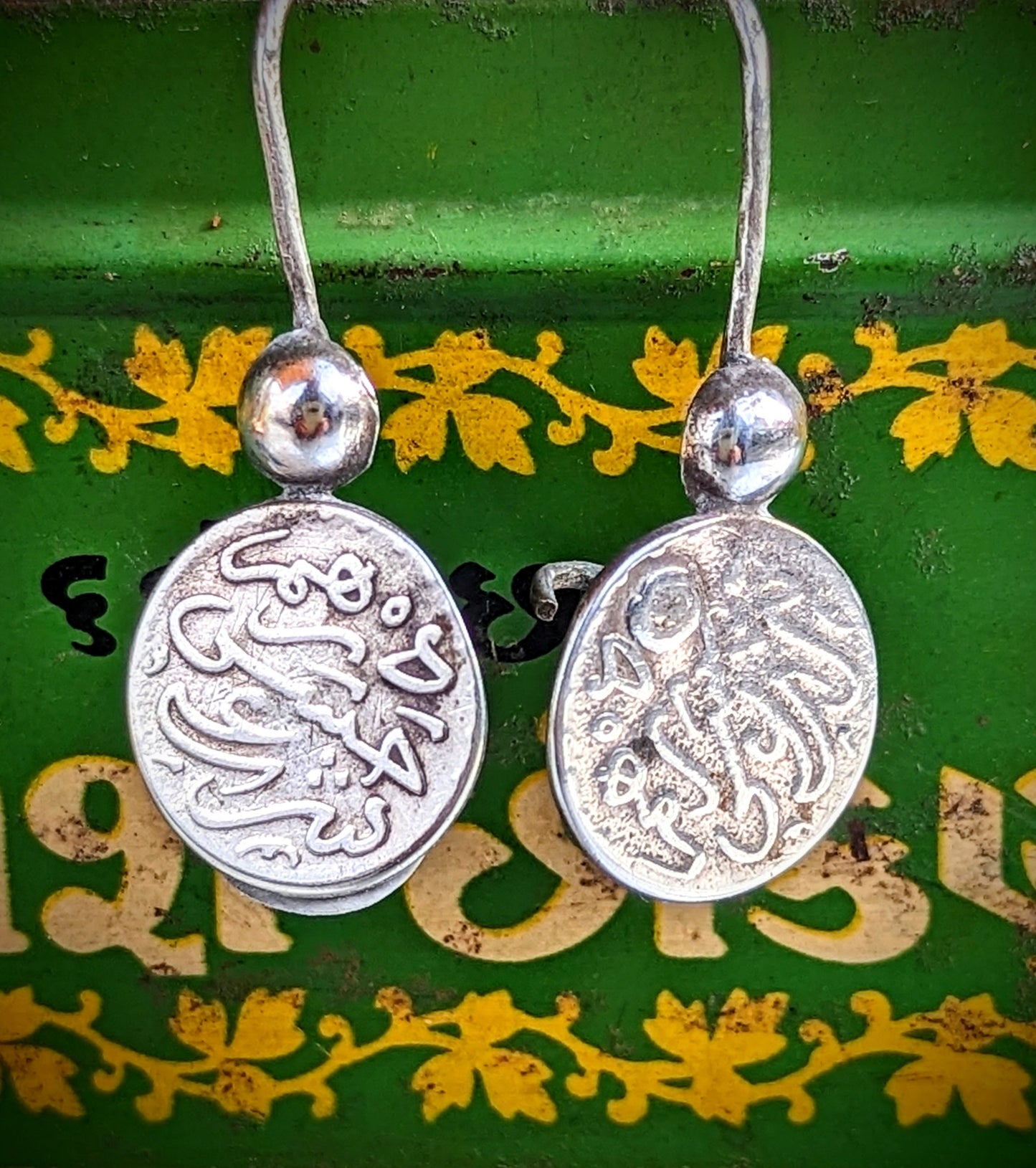 Handmade antique silver Amazigh coin earrings. These are from the Southern Atlas mountains .We love the little hands that are holding the coins!!
These are original pieces so the earring wires are slightly thicker than modern earrings.
Tribal antique silver traditionally has no hallmarks, but all that we sell have an 80-90% content, as these pieces would have been historically made from old melted down jewellery and coins.