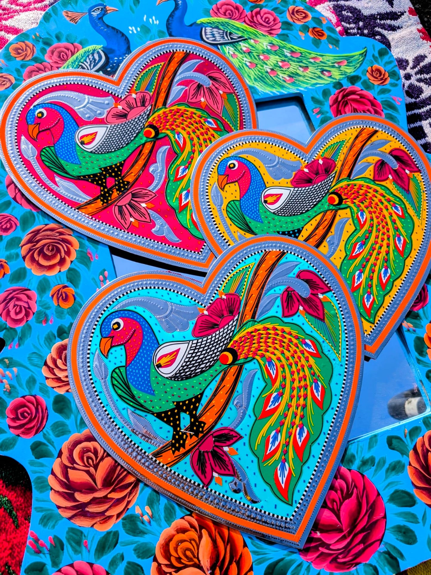 Stunning, sturdy metal love hearts, hand punched and decorated with just true loving pracocks depicted in razor cut vinyl by the truck artists of Pakistan
These traditionally are used to decorate the trucks outside or in, and are really beautifully made.
30 x 30cm
Chromed steel, vinyl sticker, fabric backed.