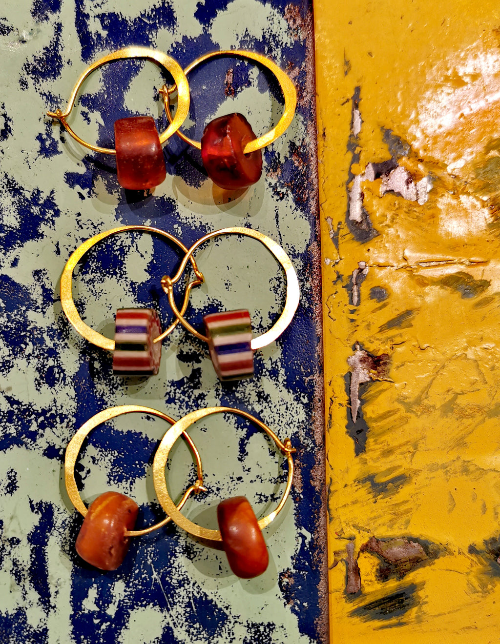 Gorgeous gold plated handmade, hammered hoops with either antique Venetian chevron trade beads ( made in the 1890's)or Tibetan Amber beads,( made approx 1800) previously threaded on a Buddhist mala.

Hoops gold plated silver 2.5cm diameter 

