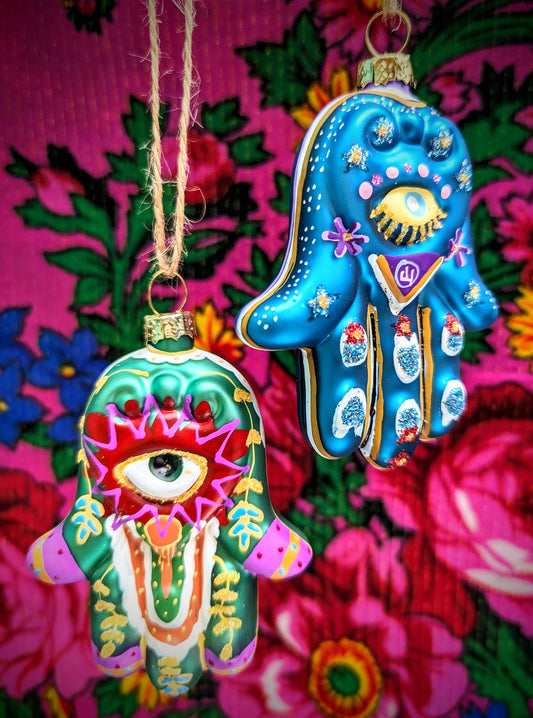 The protective all seeing eye on the palm of Fatimas hand, these beauties are a gorgeous addition to your Christmas tree or festive holiday display.

Hand finished glass decoration 

Size 9.5 x 7 x 2cm

Fragile, handle with care

Cody foster and co hand of fatima glass bauble