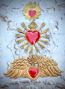 Show your devotion to love with these gorgeous golden Sacred hearts with lush red enamel centres

 All come with a metal hanging loop on the reverse. 

Imperfections may occur and are part of the charm of the wear of the materials used.

Small flaming heart 10 x 10cm

Large sun ray heart 19 x 19cm

Large winged heart 33 x 14cm

 Chehoma 
Sacred heart
