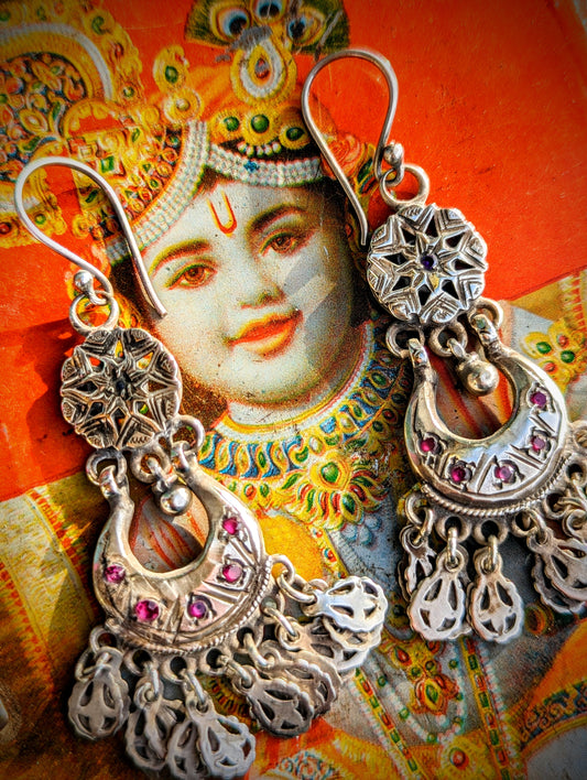 Lovely worn rare Indian antique silver earrings, incised with a fabulous star with a hanging crescent moon studded with traditional nomads pink glass stones.

These move beautifully, and are lightweight for their size

Approx 8cm length.

Antique silver, there is no hallmark as these are old country pieces, but are a high grade silver.
