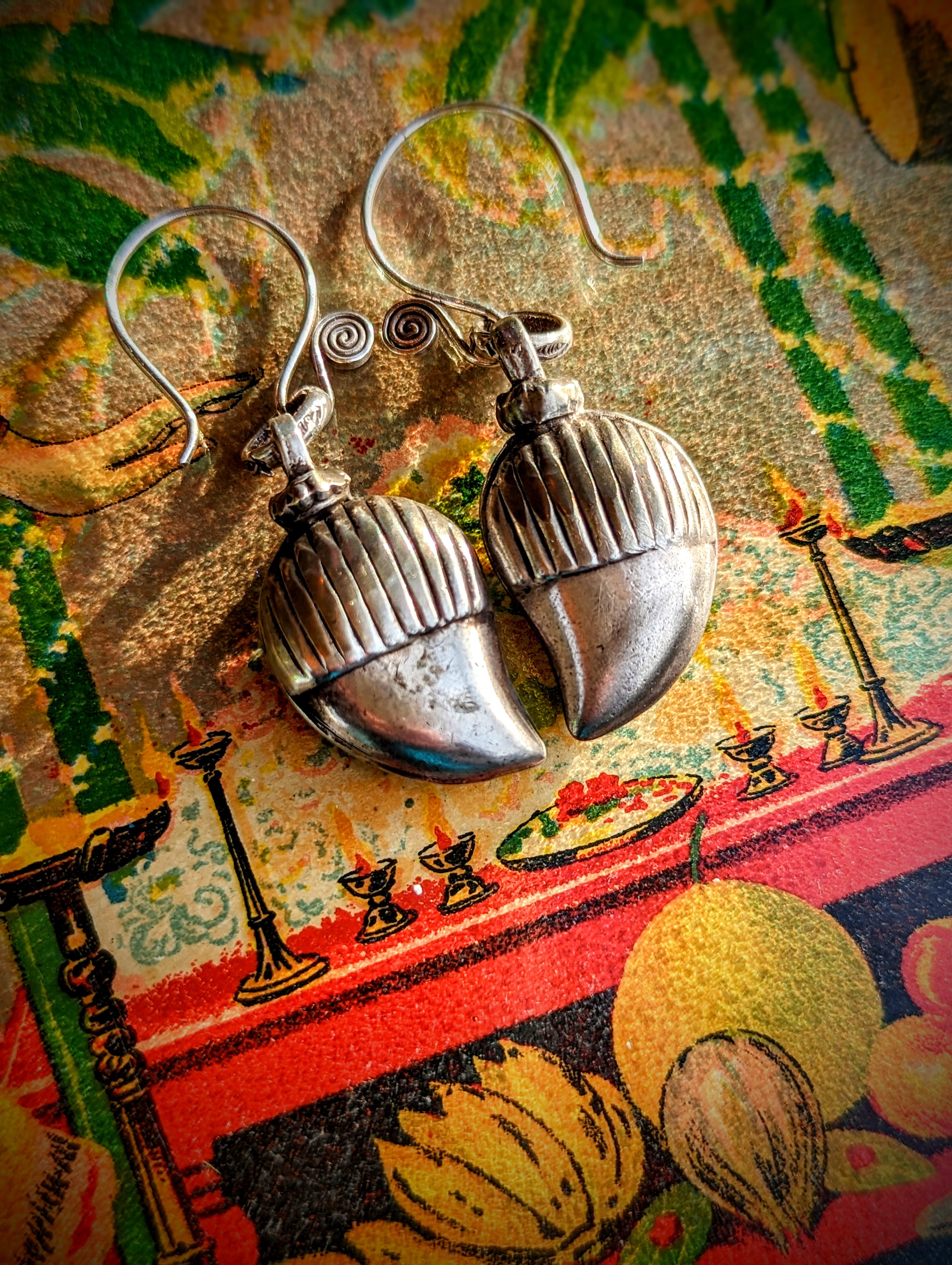 Earrings crafted by us from old silver  pendants was originally made and worn by the nomads of Rajasthan in Northern India.  It is in the shape of a mango, and is worn as a good luck and protection amulet. 

These move beautifully as all the bells are individually hung. 

Approx 4cm length.

Antique silver, there is no hallmark as these are old country pieces, but are a high grade silver. It
