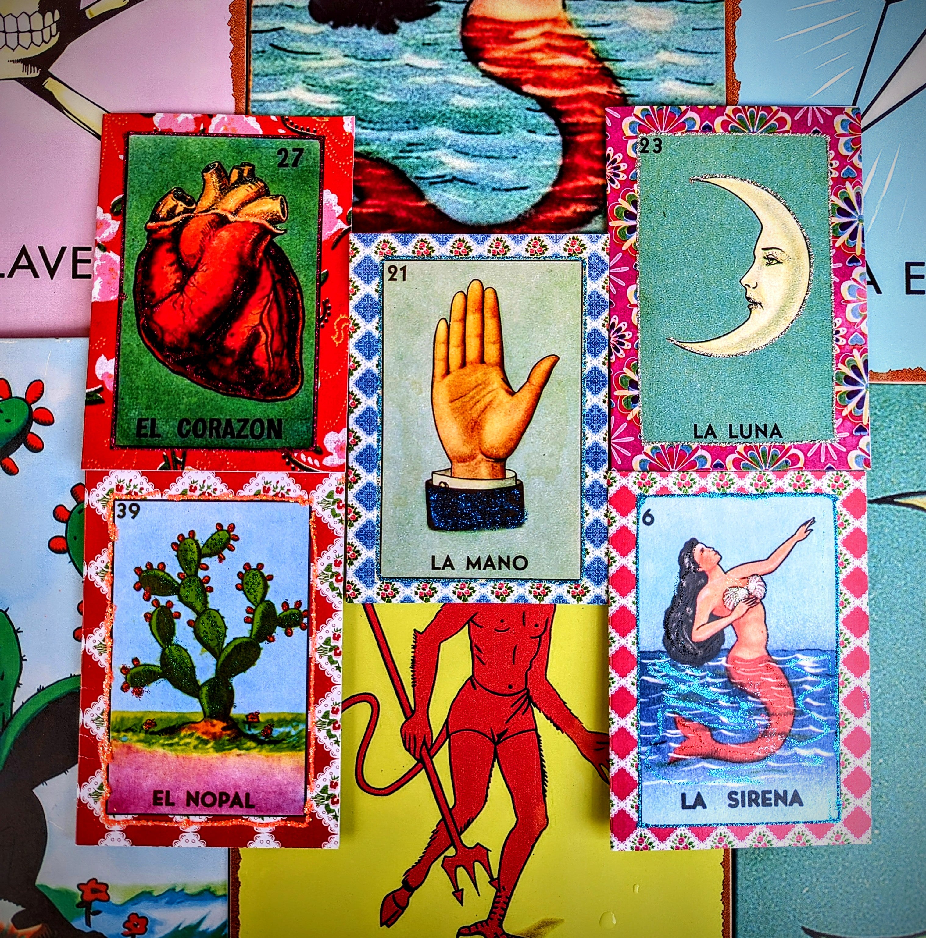 A set of five hand glittered greetings cards of iconic Mexican images from the game Loteria.
Lotteria cards
Mexican cards
Nopal
Sirena
Mano
