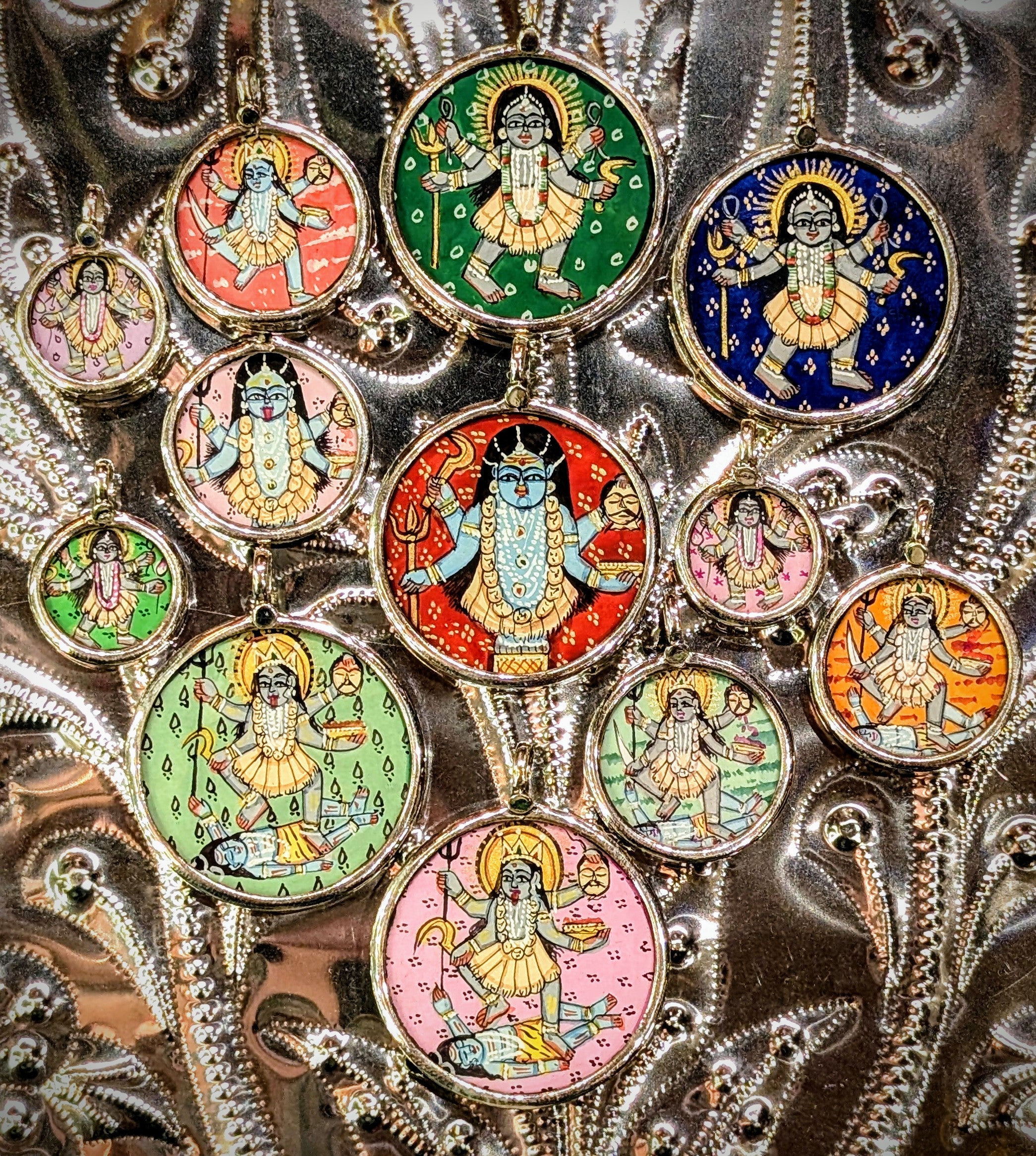 
Kali is the Hindu goddess of death and rebirth, she expresses the dual nature of the destruction that must come before new beginnings, and of the strength of the female power, she is the mother who will do terrible things to protect those who cannot protect themselves.......

in Rajasthan, these pendants are crafted from sterling silver, glass and hand painted images on paper. The fine craftsmanship in these paintings is mind blowing, painting with single paint brush bristles!!!

These pendants should be r