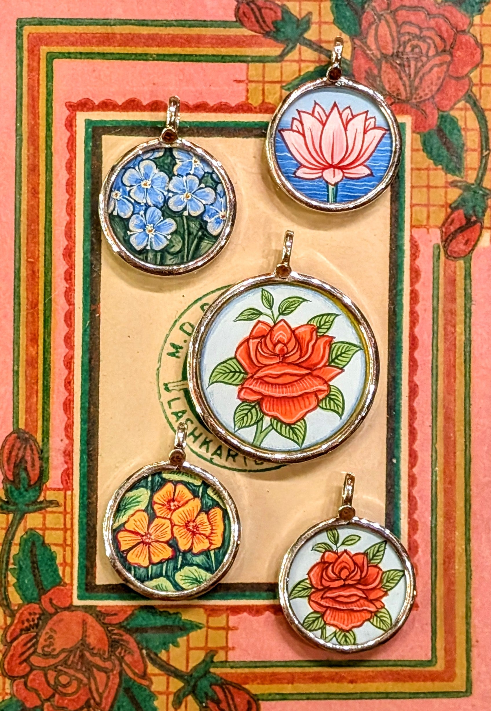 In the language of flowers, the rose is true love, the lotus is rebirth, purity and strength, the nasturtium is joy, creativity and wellness, and the forget-me-not is true love and memories
Made in Rajasthan, these pendants are crafted from sterling silver, glass and hand painted images on paper. The fine craftsmanship in these paintings is mind blowing, painting with single paint brush bristles!!!

These pendants should be removed when washing/swimming etc as they are in effect framed pieces of art, that a