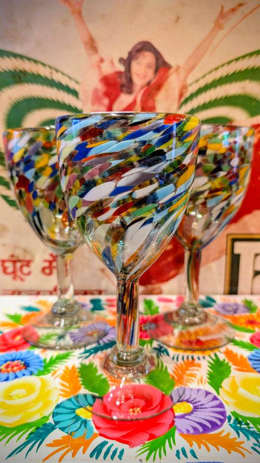 Hand blown wine glass made in Mexico from recycled glass , these are called end of day glass as they collect up all the colour bits from the coloured glass production and use them all up together!!

17 x 8.5cm approx as size can vary due to the hand made nature of the making process.

Dishwasher friendly 