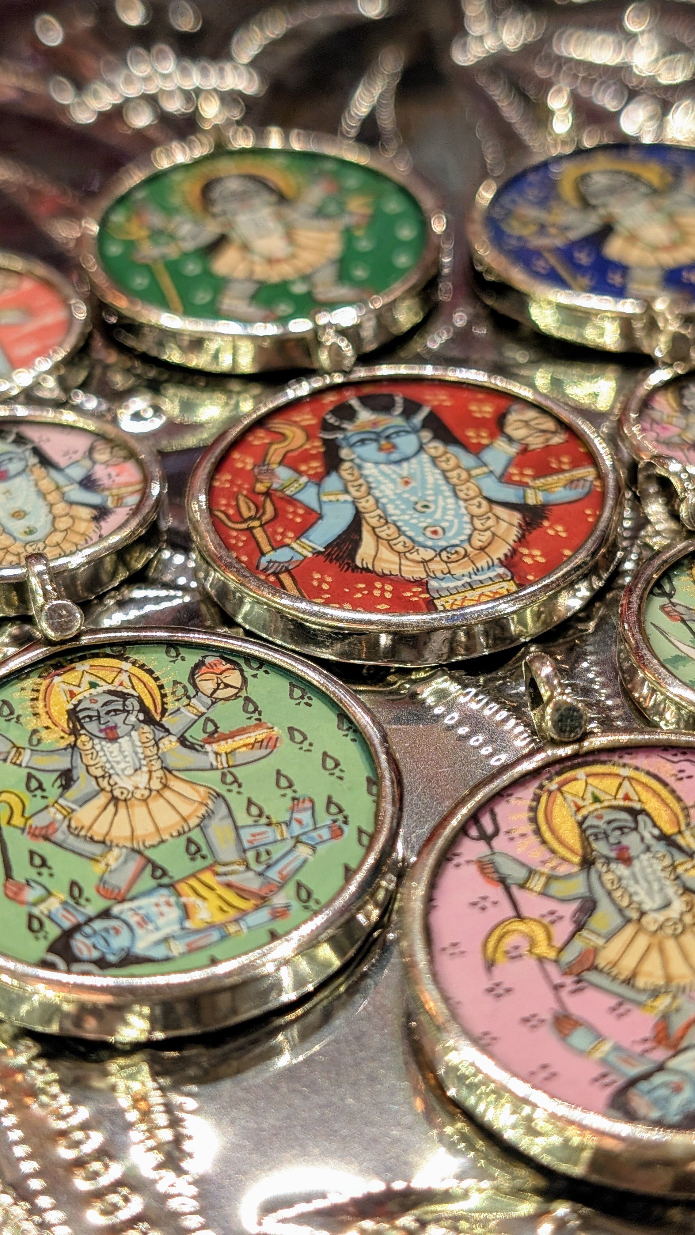 
Kali is the Hindu goddess of death and rebirth, she expresses the dual nature of the destruction that must come before new beginnings, and of the strength of the female power, she is the mother who will do terrible things to protect those who cannot protect themselves.......

in Rajasthan, these pendants are crafted from sterling silver, glass and hand painted images on paper. The fine craftsmanship in these paintings is mind blowing, painting with single paint brush bristles!!!

These pendants should be r