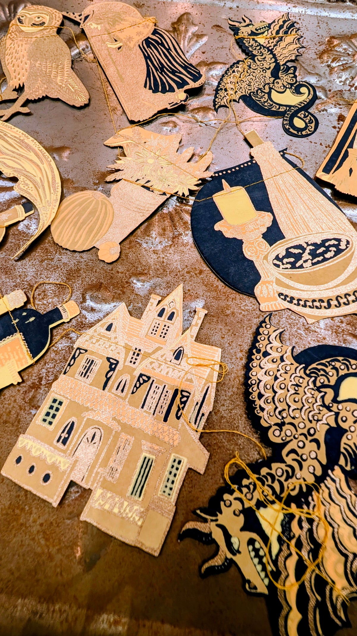 Celebrate the Gaelic festival of Samhain and the start of the darker half of the year with this hand printed three metre long paper garland, featuring ten screen printed witches, moon, magical dragons and all you will need!.

The garland is printed on both sides on thick, hand made cotton paper.  The shapes are sewn in a random order along strong cotton thread, with hanging loops either end, meaning you can hang your garland straight away!
East end press Samhain garland 