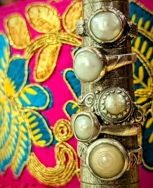 In Northern India pearls are considered to be the daughter of the moon, and to wear a pearl ring it is believed to bring emotional balance, mental peace and good health, whilst also bringing harmony in relationships and protecting against negativity....well who doesn't need a bit of that!?!?!
1980s Rajasthanil rings, handmade in and around Pushkar from silver with real pearls.
Numbered from top to bottom.
These pieces vary in wear and tear, so please examine images!

Tribal antique silver traditionally has 