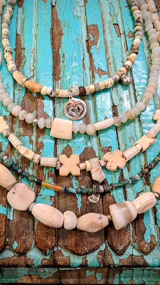 These ancient antique beads are excavated in Mali and Ivory Coast .They were traditionally buried under the threshold of the home and places of worship for protection and good luck.

The ancient stone necklaces are agates, alabaster and some fossilised shell, the beads are hundreds of years old.

The glass beads are Roman period.

We have threaded them up with antique Indian silver amulets and beads too.

The patina on the beads is beautiful, they are aged and frosted by generations of wear and being in the