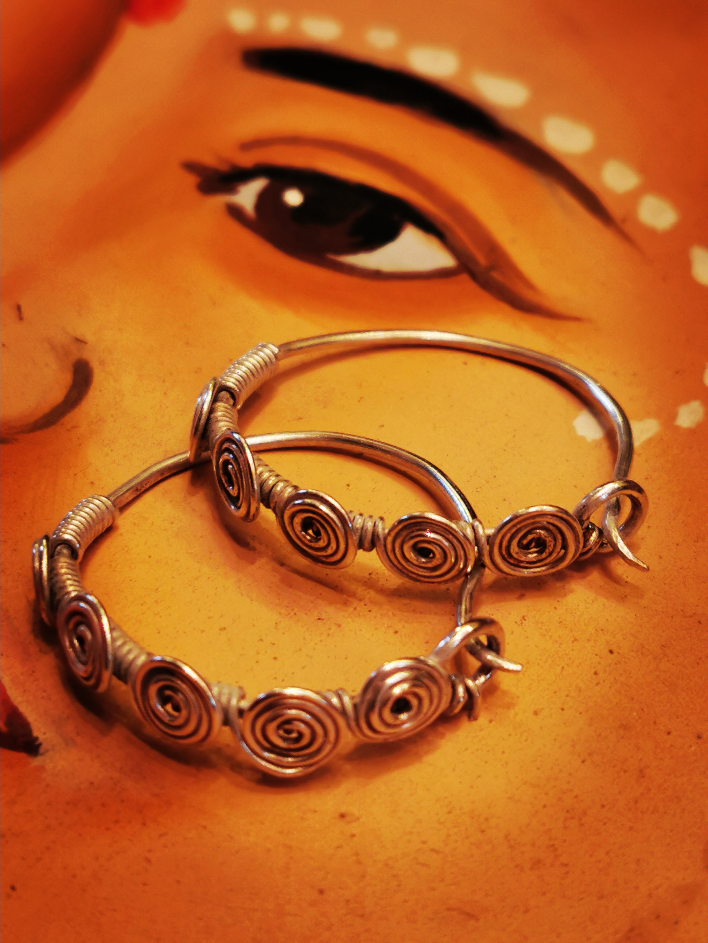 Traditional silver Rajasthani hoops decorated with fancy hand done spiral wire work, a traditional craft in the Desert area of Pushkar.

3. 5cm x 3.2cm

92.5% silver

