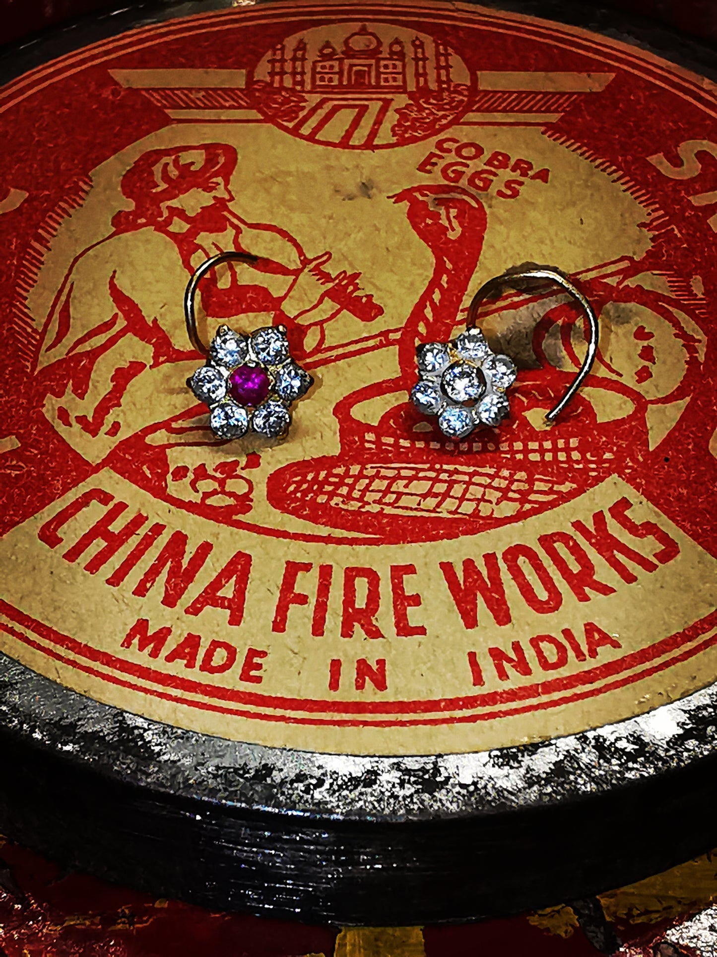 Traditional Indian gold nose stud, floral designs on a spiral wire typical of Rajasthan.

9ct gold set with cubic zirconias.

5mm diameter flower. 

