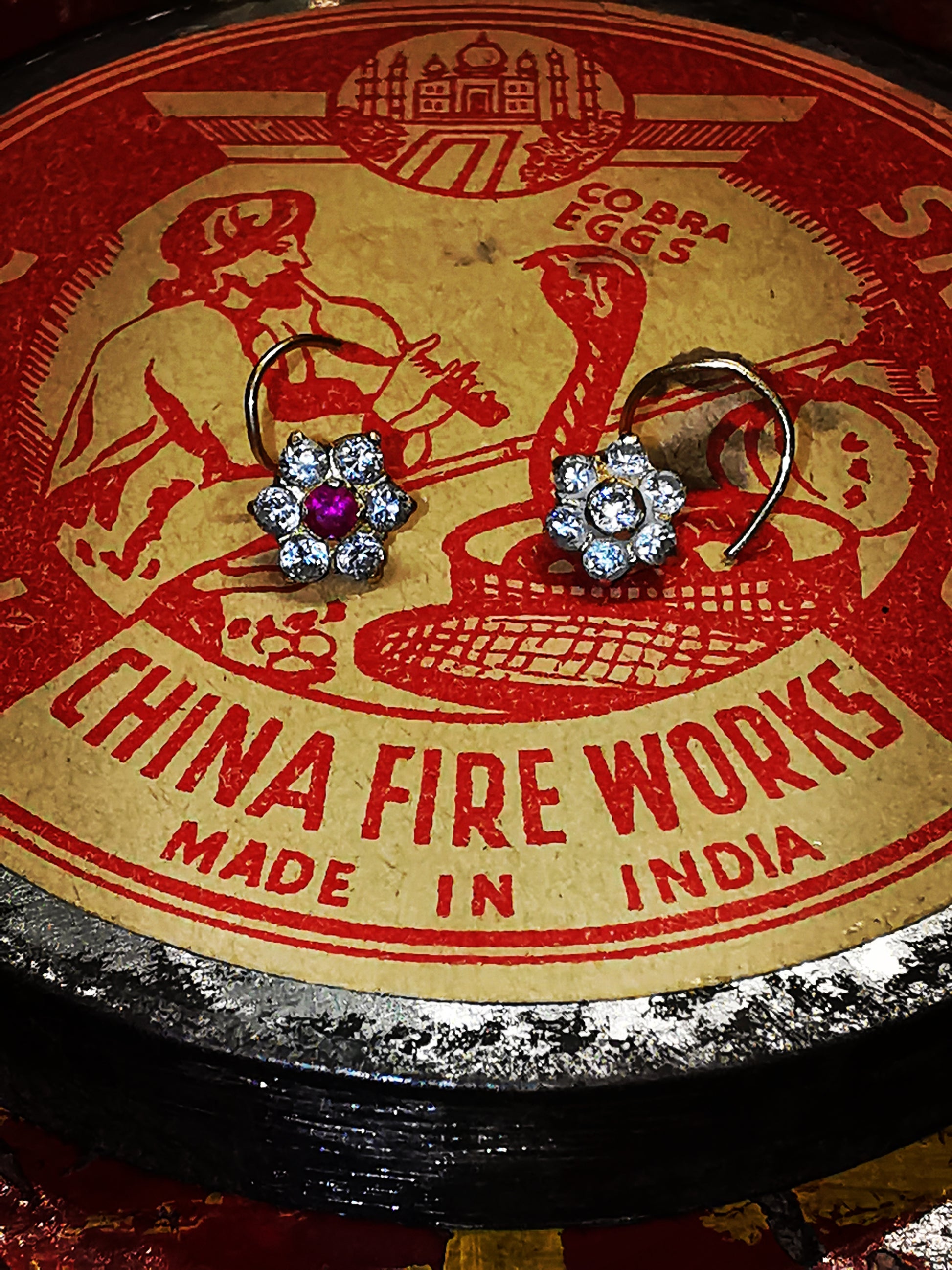 Traditional Indian gold nose stud, floral designs on a spiral wire typical of Rajasthan.

9ct gold set with cubic zirconias.

5mm diameter flower. 

