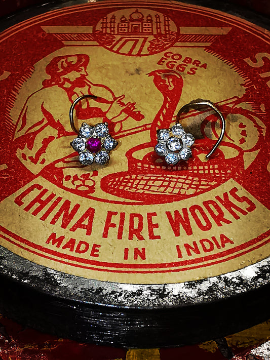 Traditional Indian gold nose stud, floral designs on a spiral wire typical of Rajasthan.

9ct gold set with cubic zirconias.

5mm diameter flower. 

