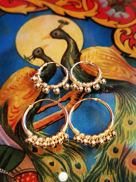 Bobbly beads hand from these hand-wire worked hoops. 

Gold-plated silver

15mm small

20mm large

Plated jewelry must be treated with care, to keep the plate rich for as long as possible remove when washing, applying creams, using detergents etc. 

