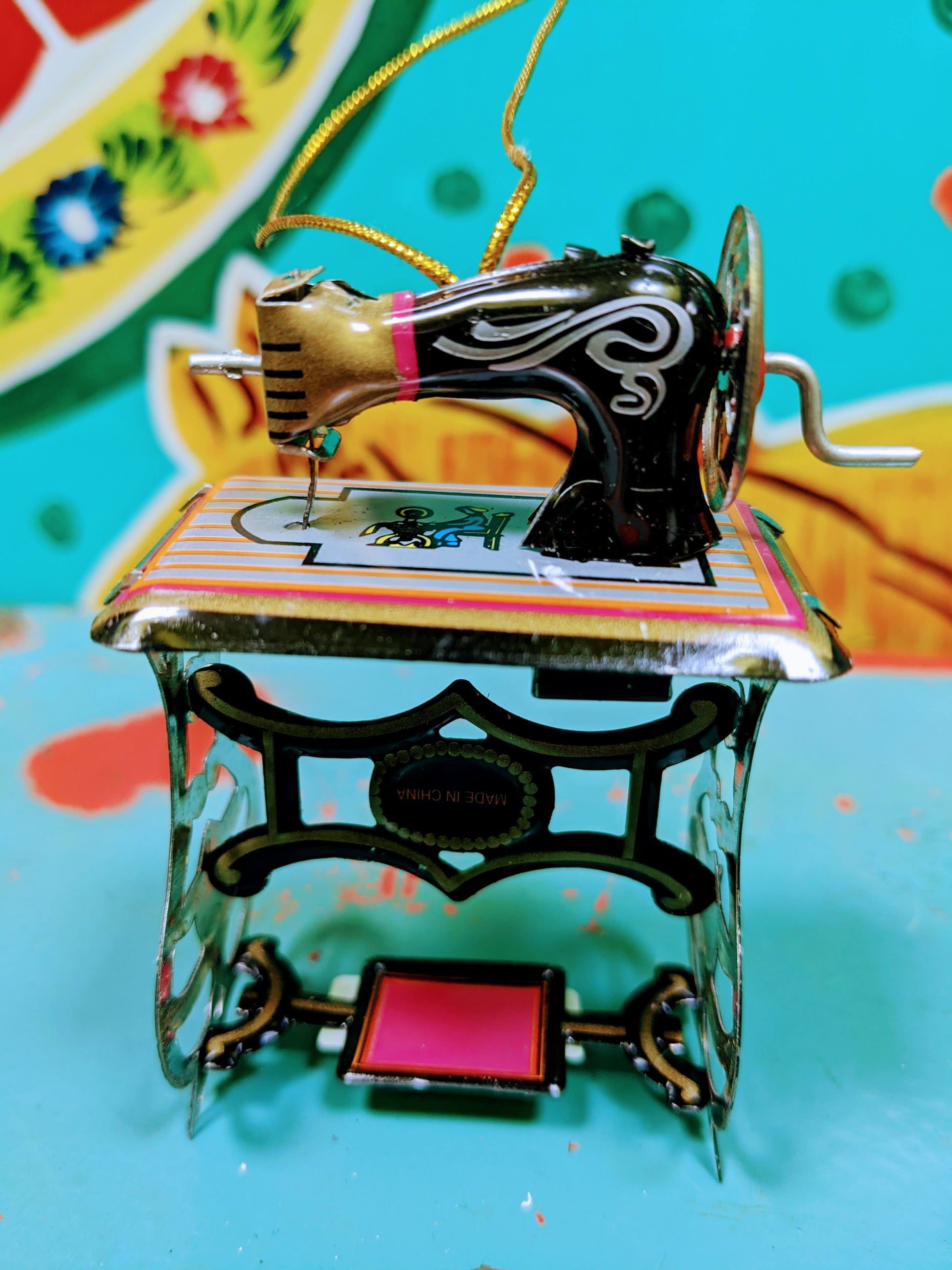 Miniature tin Sewing machine even has an interactive handle for sewing.